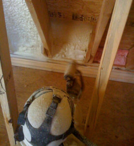 spray foam insulation being applied in an unfinished wall.