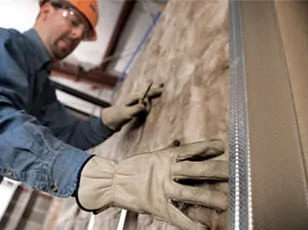 A technician installing batt insulation